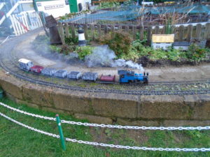 Model railway train going round a track outside