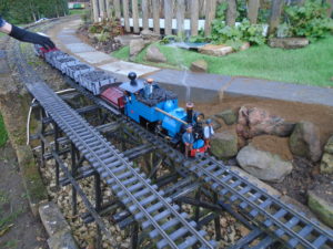 Model railway train going round a track outside